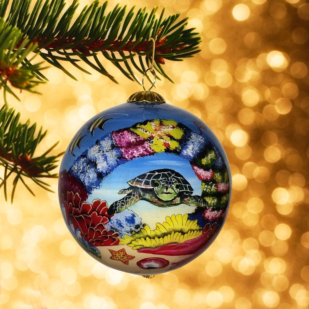 Handpainted Hawaiiian Christmas ornament showing sea turtles, coral and tropical fish against a Christmas tree background